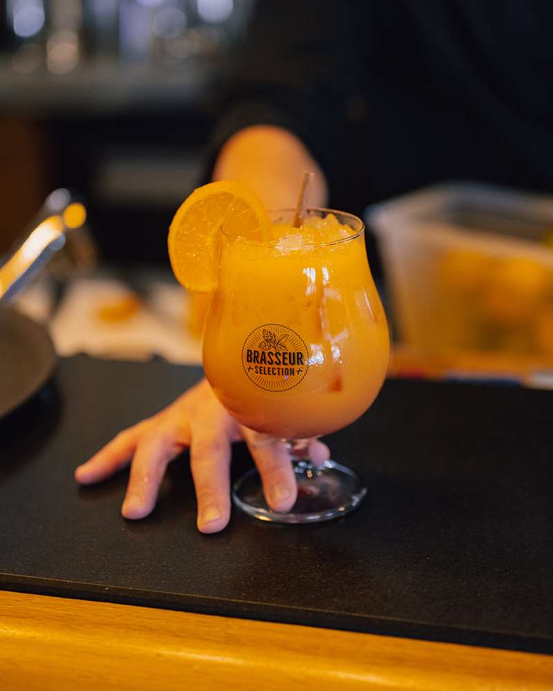 Cocktail orange et sa rondelle d'orange, servi au bar